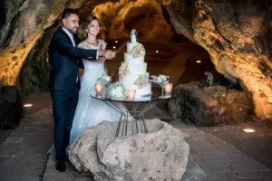 Momento magico del taglio della torta all'interno della suggestiva grotta durante un matrimonio al Gibò.