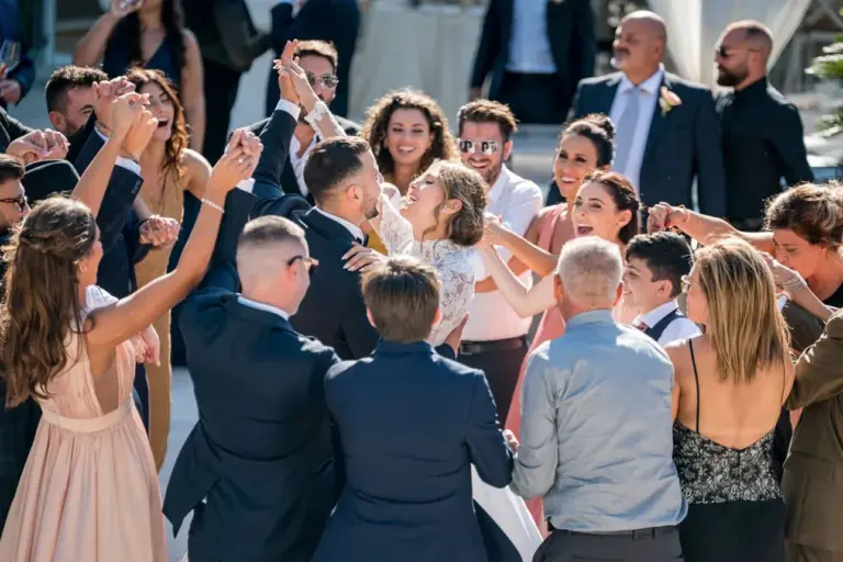 Esplosione di gioia nella galleria di Maraca Fotografia: gli sposi ballano circondati da amici festosi. Un'immagine che racconta la felicità condivisa e la vivacità di un momento indimenticabile di celebrazione