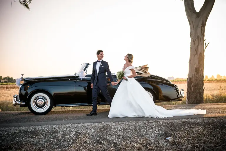 gli sposi eseguono uno shooting fotografico con una splendida Rolls Royce cabrio