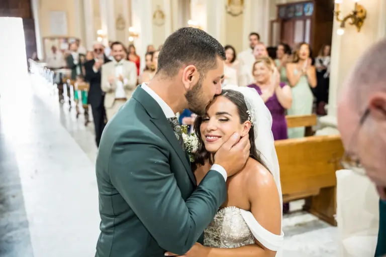 lo sposo bacia la sposa dopo il suo ingresso in chiesa