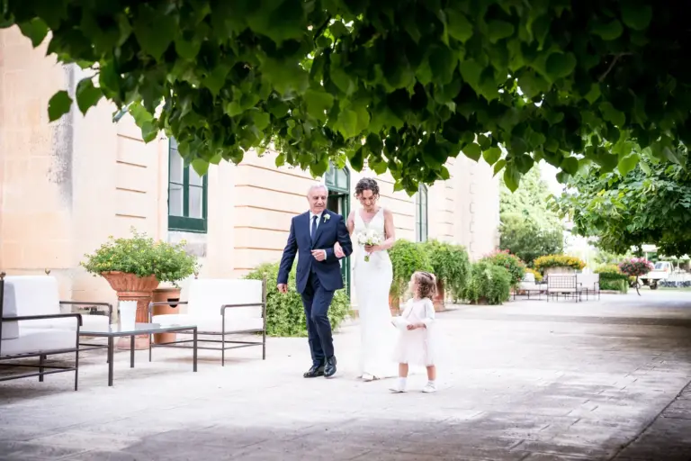 Matrimonio a Tenuta Lucagiovanni Maglie. Il papà accompagna la sposa verso lo sposo