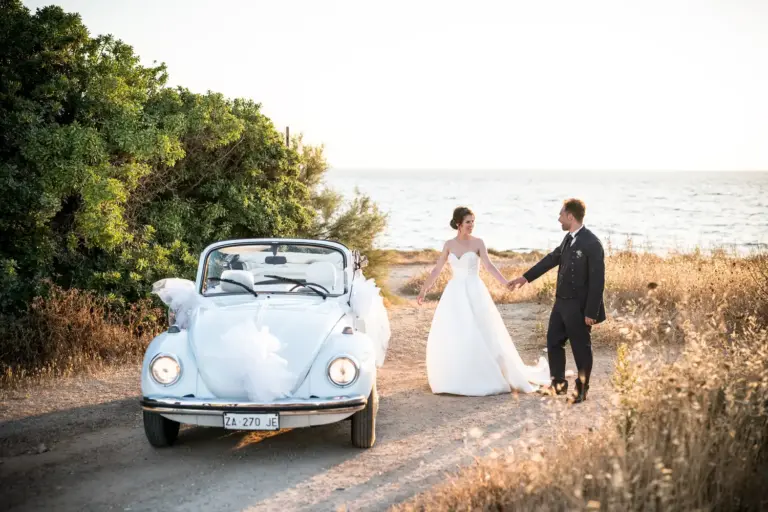 Matrimonio a Gallipoli, gli sposi con il maggiolino bianco auto scelta dalla sposa per gli spostamenti